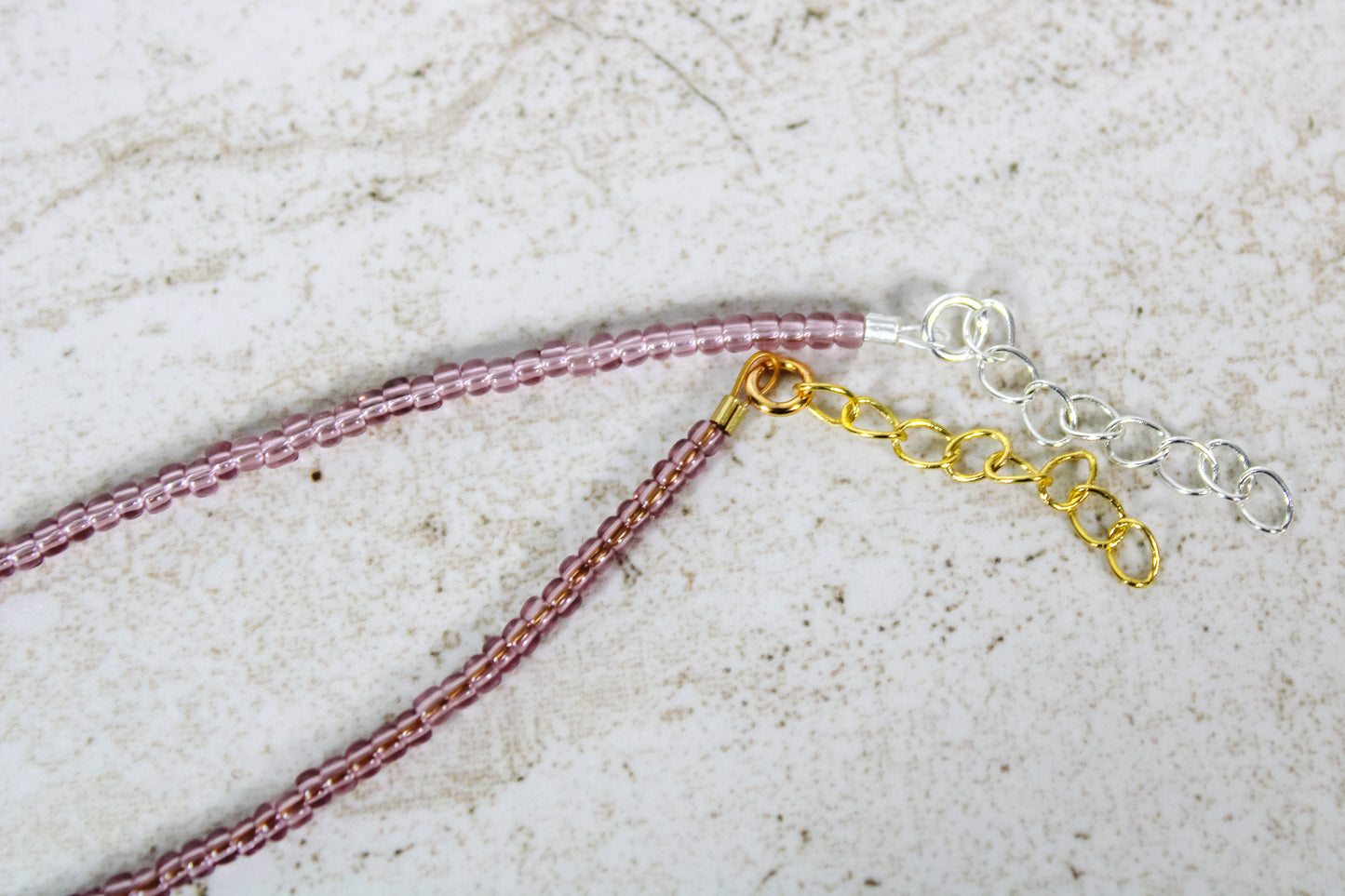 A close up of the gold and silver extender chains on a garnet bracelet.