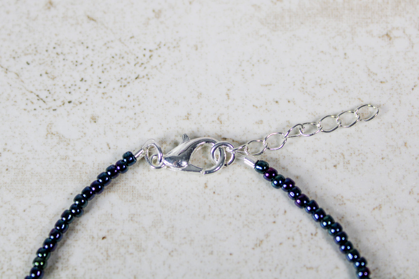 Detailed shot showing the silver lobster clasp connected to the adjustable extender chain for the Just Dance bracelet.