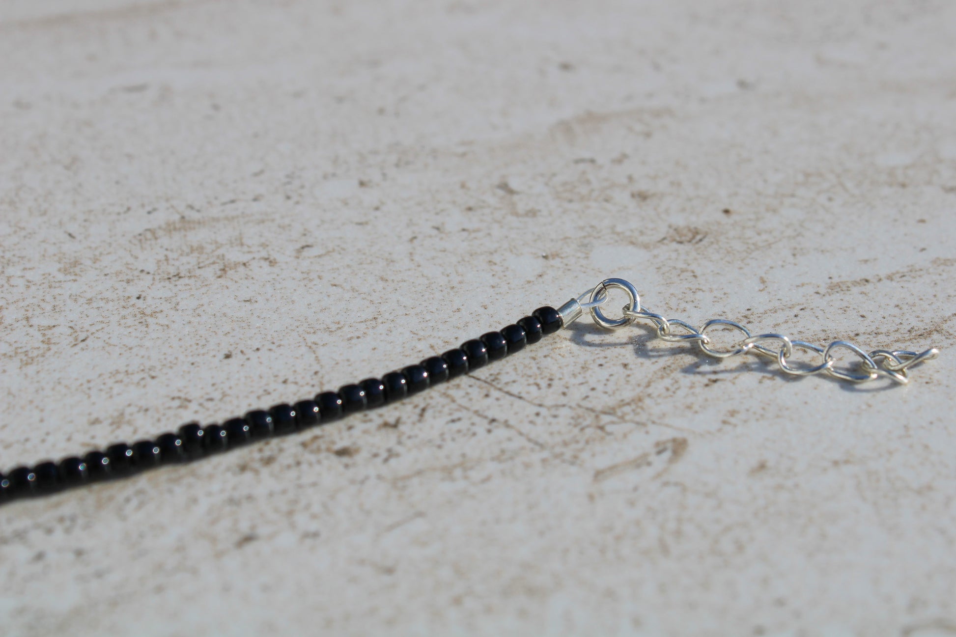 A close up of the silver 1 inch extender chain.