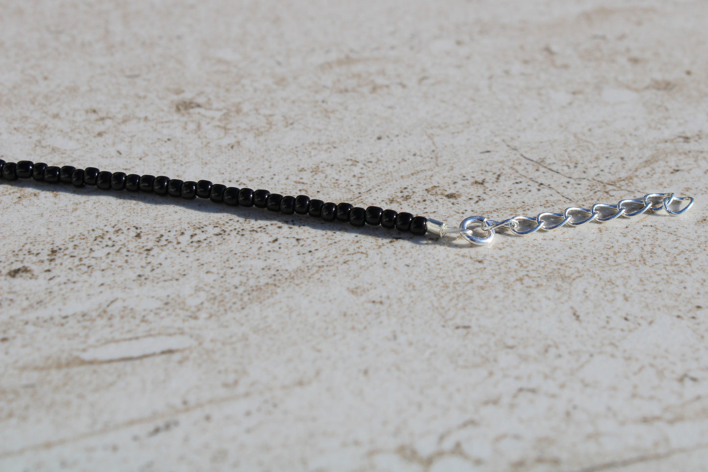 A close up of the silver 1 inch extender chain.