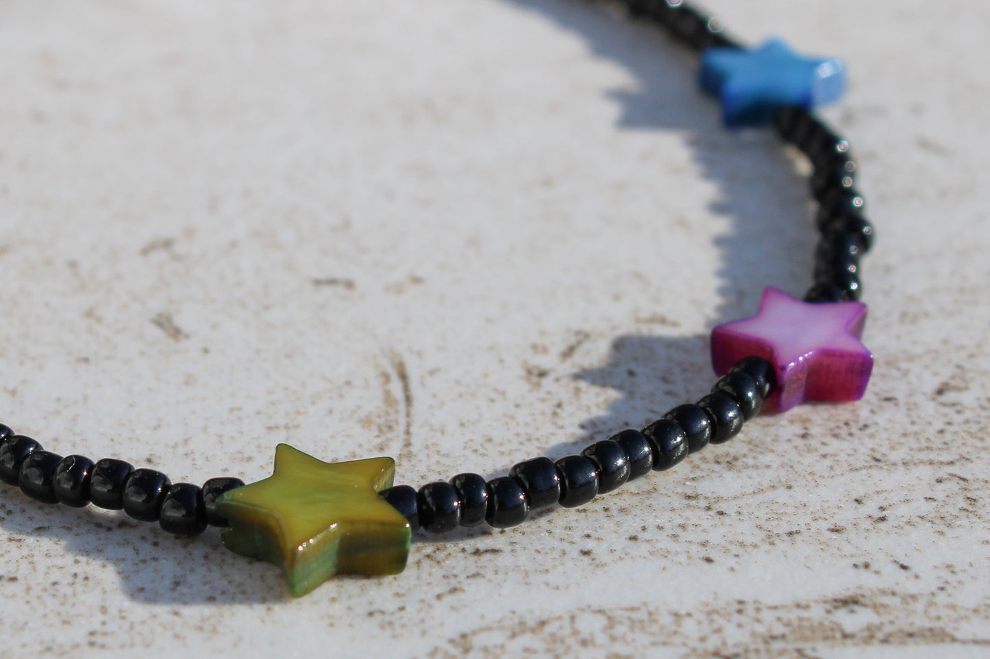 A close up of the green, purple, and blue shell star charms.