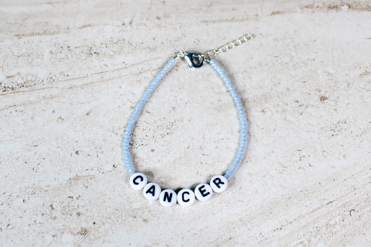 Soft and shimmering Cancer zodiac bracelet with silver hardware, displayed on a clean background.