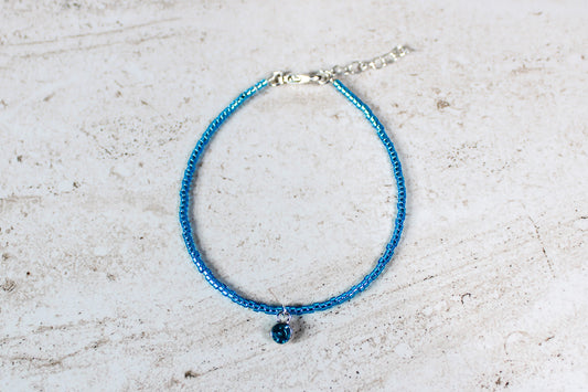 A full view of the December birthstone bracelet, featuring vibrant blue seed beads and a silver finish, displayed on a neutral background.