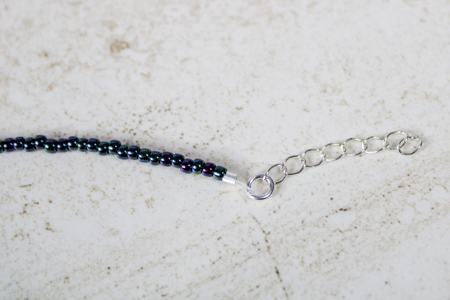 Close-up of the silver extender chain showing the adjustable length of the Just Dance seed bead bracelet.