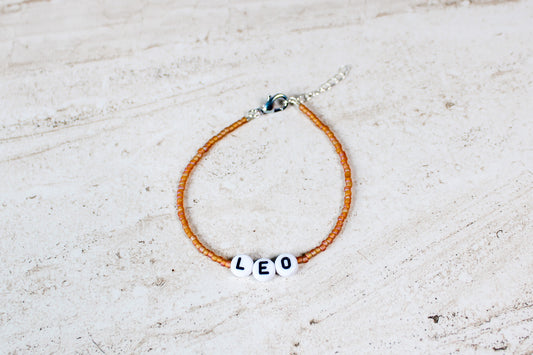 Leo bracelet with fiery beads and silver finish hardware, styled flat to showcase color and structure.