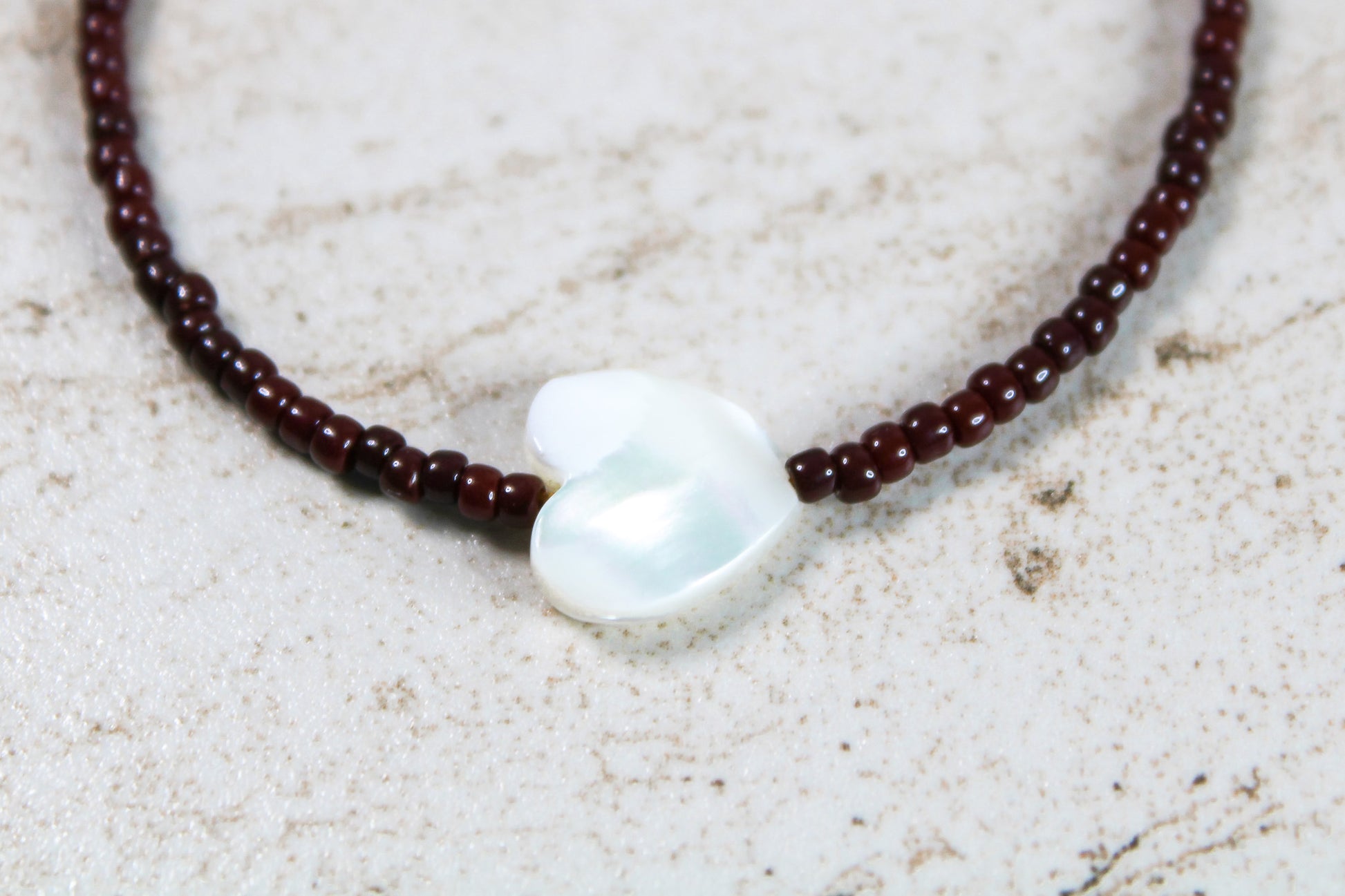 A close up of the oxblood red seed beads and shell heart.