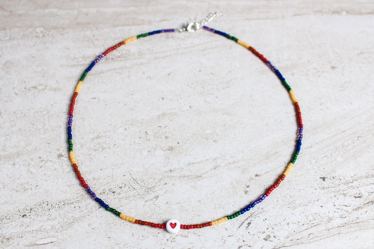 Rainbow Pride beaded necklace laid flat to show full length and gradient of seed beads transitioning through red, orange, yellow, green, blue, and purple.